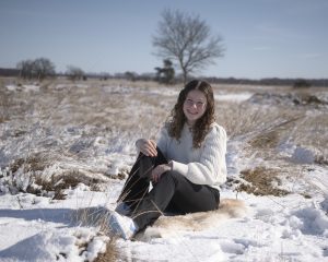 meisje zittend in de sneeuw