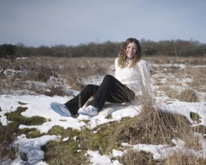 meisje achterover zittend in de sneeuw