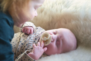 baby met speen en zusje