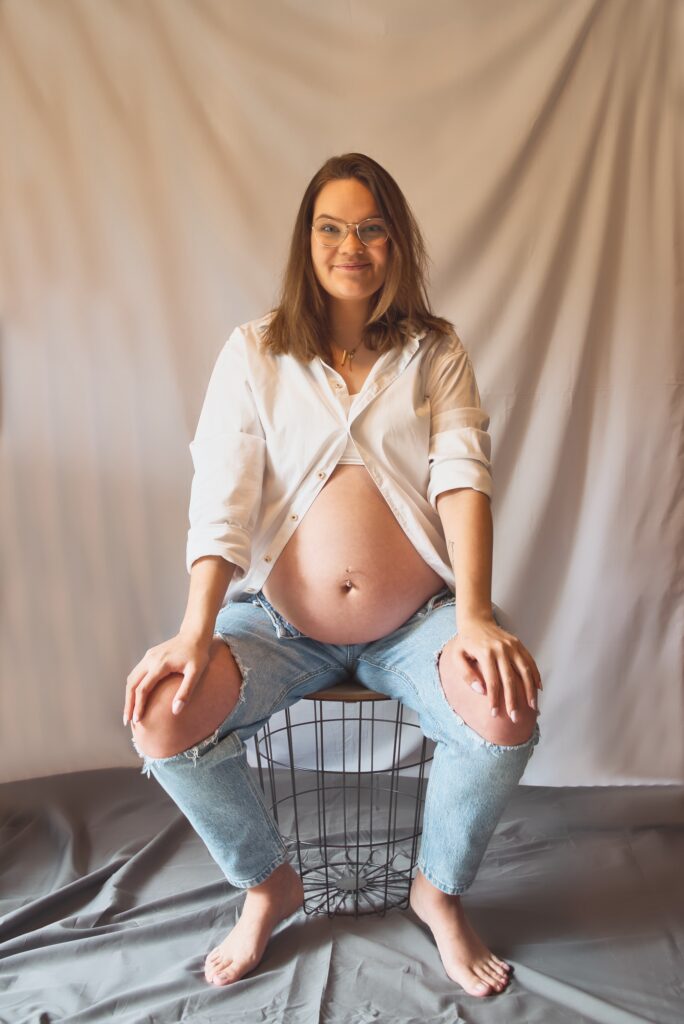 zwangere vrouw zittend op een krukje