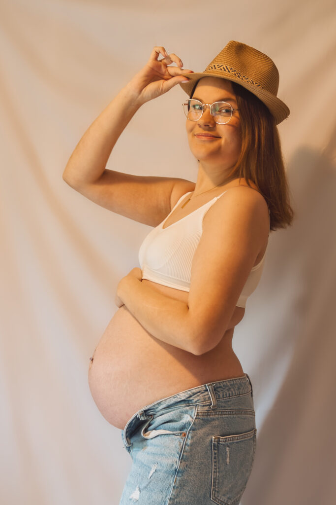 staande zwangere vrouw met hoedje op