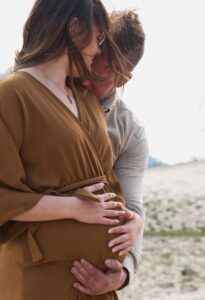 zwangere vrouw man houdt buik vast