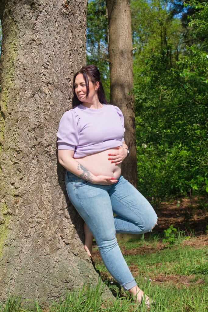 zwangere dame met paars shirt en spijkerbroek