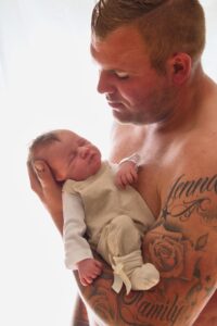 papa in bloot bovenlichaam met baby op de arm