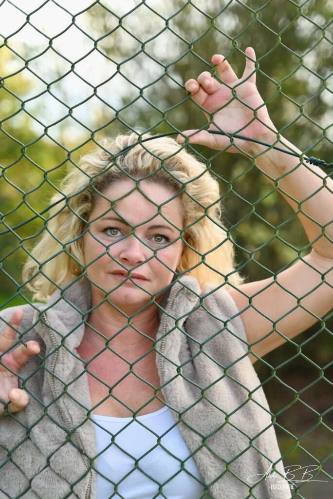 *blonde dame houden achter een hek