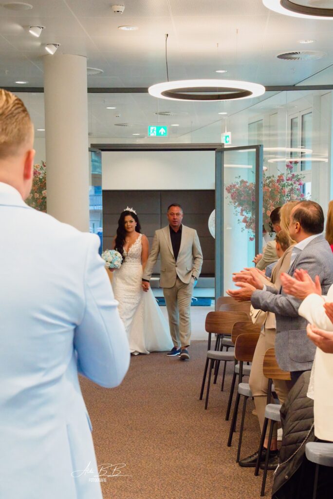 *bruid loopt naar voren met vader