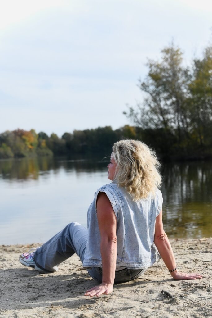 blonde dame zittend aan het strand