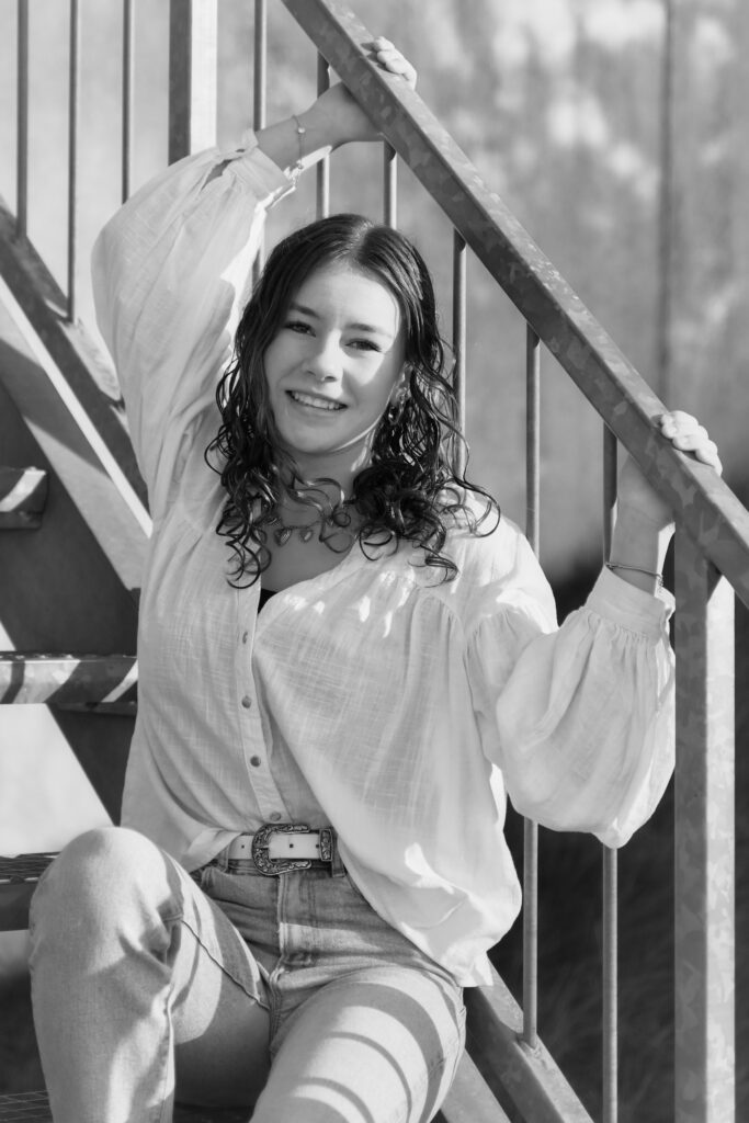 *jonge dame zittend bij een trap zw