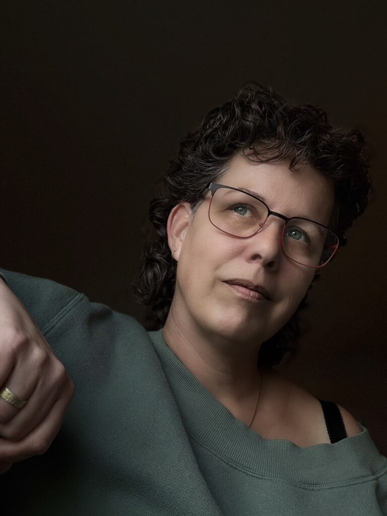 ik met groene trui voor een donkere achtergond